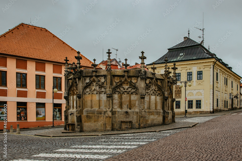 Stone Fountain in historical Town Center with cobblestone street, colorful facades, Kutna Hora, Czech Republic.UNESCO world heritage site.Czech popular tourist destination.European Cityscape