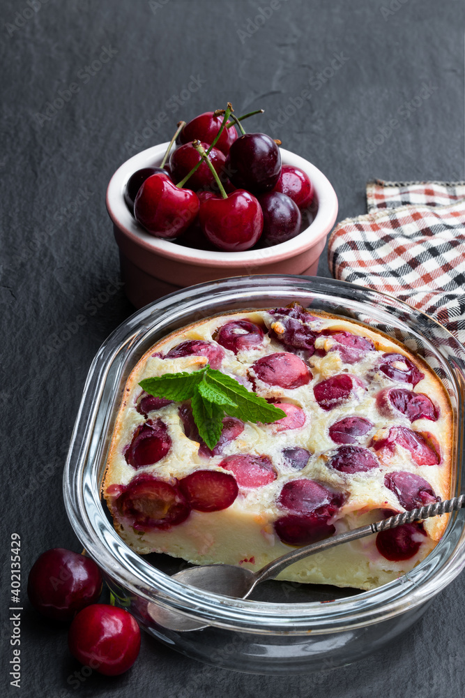 Clafouti cherry pie on black stone background Clafouti cherry pie on black stone background