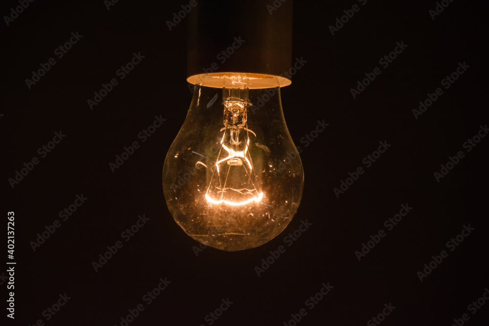 Glowing light bulb on black background with copy space close up