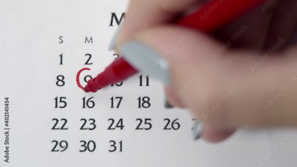 Female hand circle day in calendar date with a red marker. Business Basics Wall Calendar Planner and Organizer. MARCH 9th Female hand circle day in calendar date with a red marker. Business Basics Wall Calendar Planner and Organizer. MARCH 9th