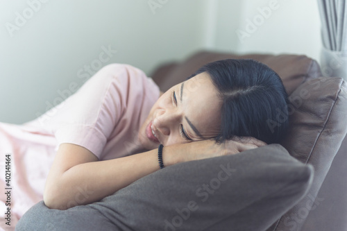Woman lying on sofa in living room.