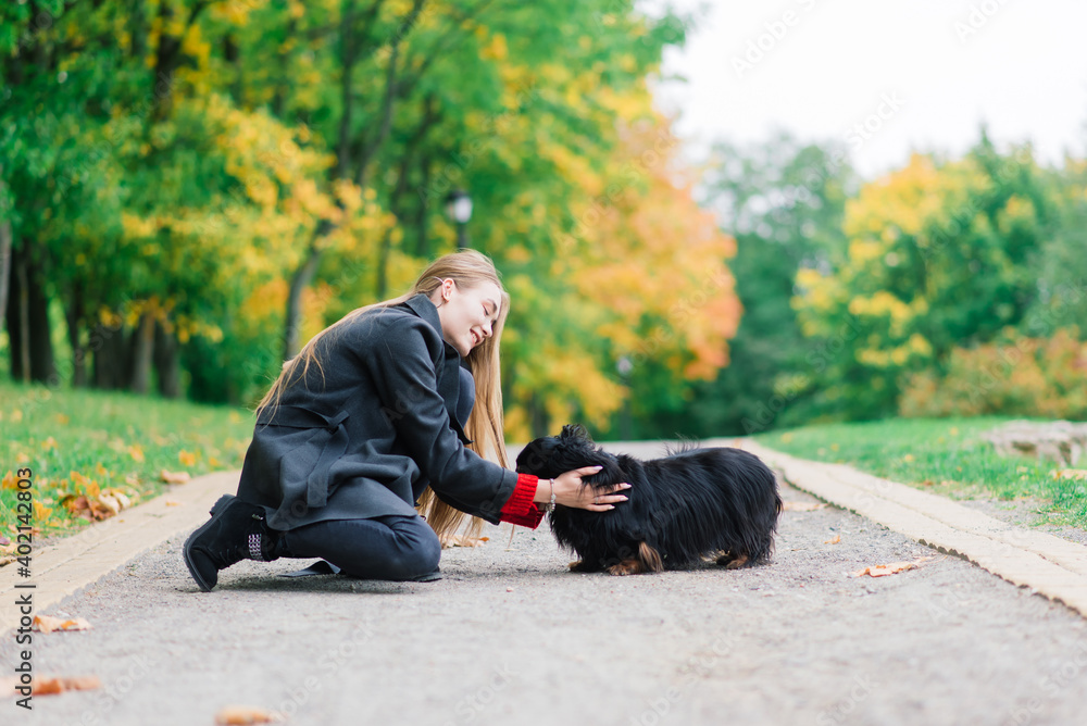 Happy woman holding her little dog in arms Happy woman holding her little dog in arms