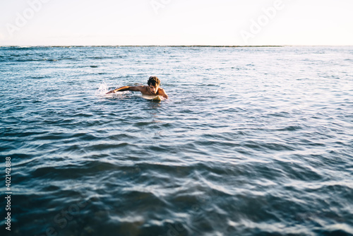 Sportive man surfing on sea waves