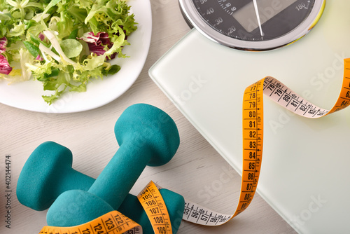 Healthy lifestyle background with dumbbell salad and weight control top
