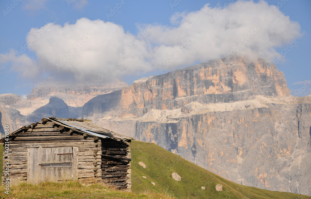 Drewniany szałas na tle górskich szczytów, Dolomity