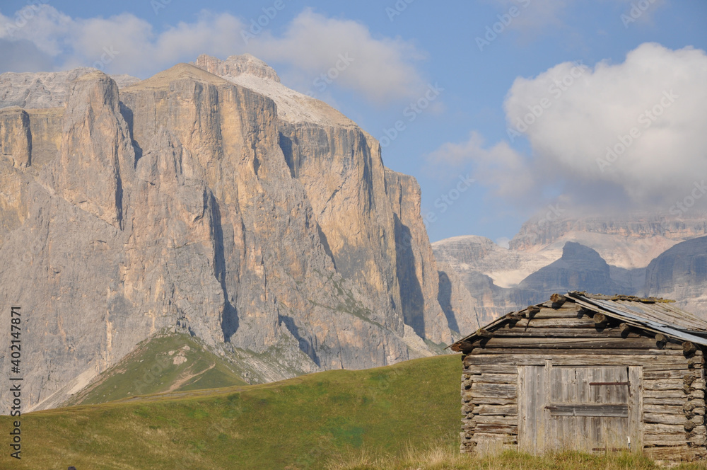 Drewniana chata na tle stromych górskich ścian, Dolomity