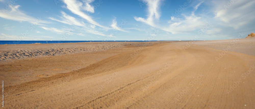Na brzegu morza bardzo szeroka piaszczysta plaża. - obrazy, fototapety, plakaty 