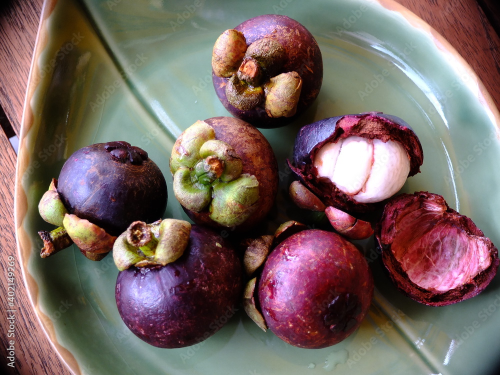 Obraz premium Mangosteen (Garcinia mangostana) on a green platter
