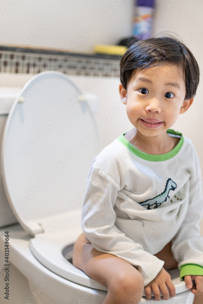 A boy is sitting on toilet with suffering. A boy is sitting on toilet with suffering.