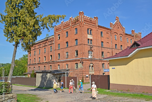 OZERSK, RUSSIA - AUGUST 24, 2019: Tourists pass near the building of the old water mill. Kaliningrad region photo