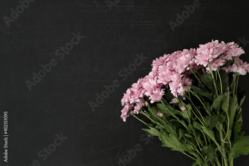 Beautiful pink flowers on blackboard  flat lay with space for text. Happy Teacher s Day