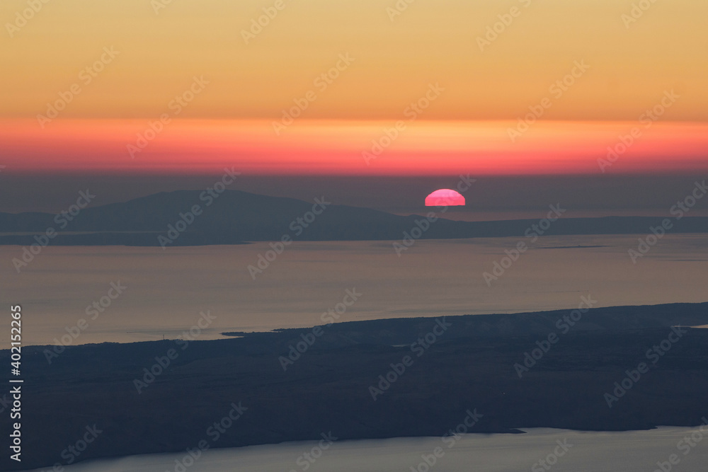 Sun hiding behind horizon of Adriatic sea.