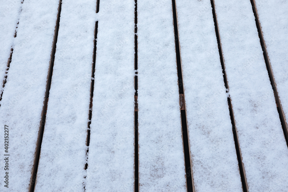 Wooden floorboards half covered with wet snow. Snow on a wooden terrace Wooden floorboards half covered with wet snow. Snow on a wooden terrace