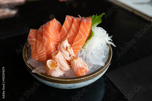 Raw sashimi salmon sliced and smoked salmon on ice in bowl