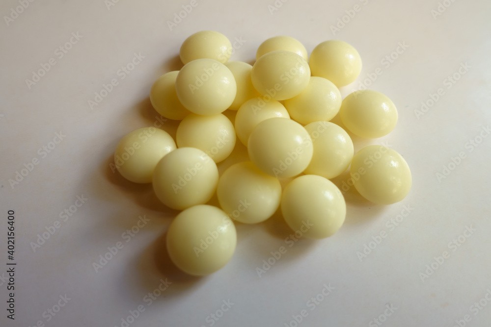 Closeup of handful of light yellow mints of xylitol Closeup of handful of light yellow mints of xylitol