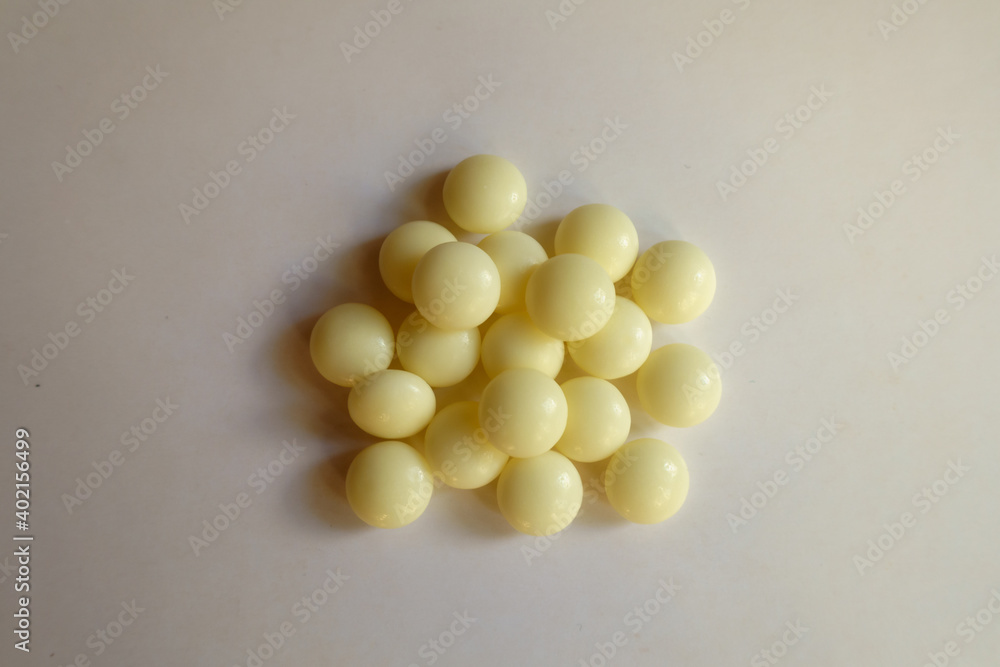 Heap of light yellow mints of xylitol from above Heap of light yellow mints of xylitol from above