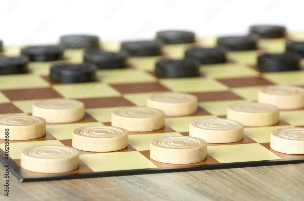 checkers or draughts is a board game. Close Up of wooden round checkers. white background with space for text checkers or draughts is a board game. Close Up of wooden round checkers. white background with space for text