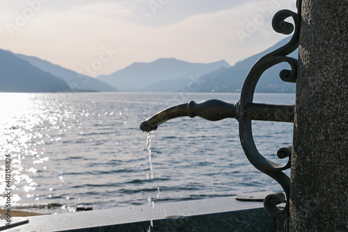 Drinking water tap on the Lake Ceresio at Bissone near Lugano. Switzerland. photo