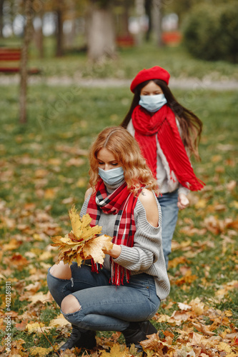 Family in a autumn park. Coronavirus theme. Mother with daughter.