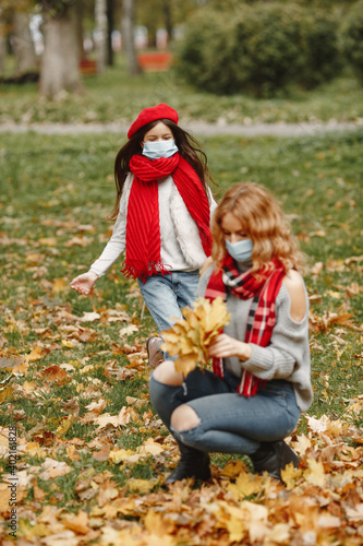 Family in a autumn park. Coronavirus theme. Mother with daughter.