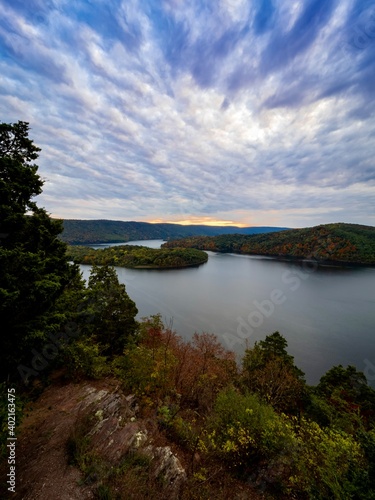 Hawn’s Overlook of Raystown Lake in the mountains of Pennsylvania in the fall right before sunset with a dramatic blue swirly sky with orange tones in it and water as smooth as glass. © Christina Saymansky