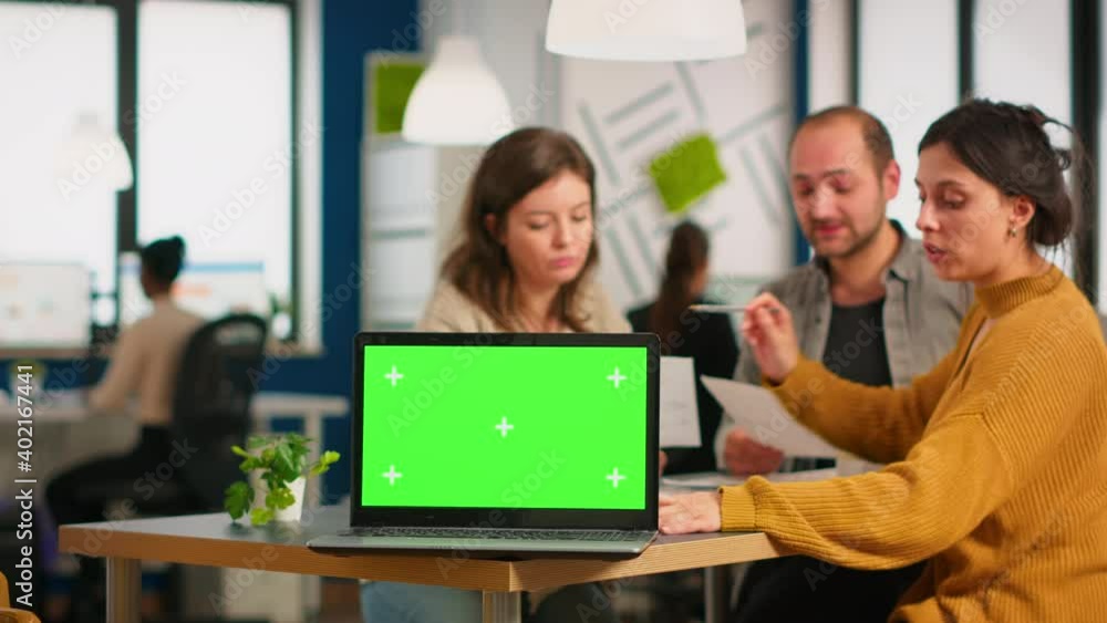 Group of business people discussing company plan with mockup laptop in front of camera, pc ready for financial project presentation placed on desk. Leader using green screen pc with chroma key display Group of business people discussing company plan with mockup laptop in front of camera, pc ready for financial project presentation placed on desk. Leader using green screen pc with chroma key display