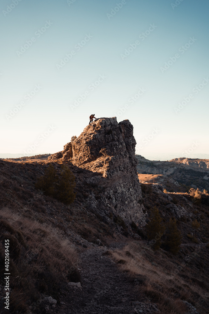Fototapeta premium Man in the mountain at sunset. Guy practicing trekking