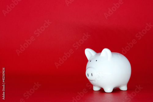 White Piggy bank isolated on red background with copy space for text message - Fund , Investment , Saving money - Red concept of Banking and finance concept 