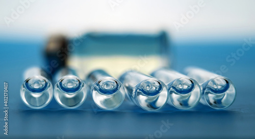 Ampoules and medicine bottle for injections on blue surface, selective focus