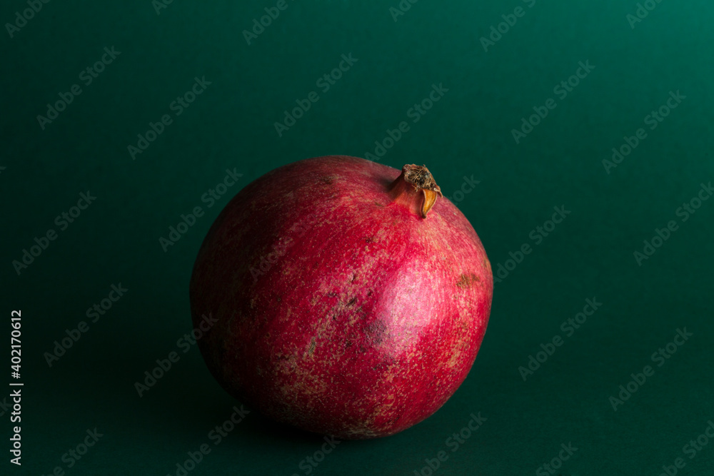 ripe red pomegranate fruit on green background with copy space for your text, healthy vegetarian diet top view ripe red pomegranate fruit on green background with copy space for your text, healthy vegetarian diet top view
