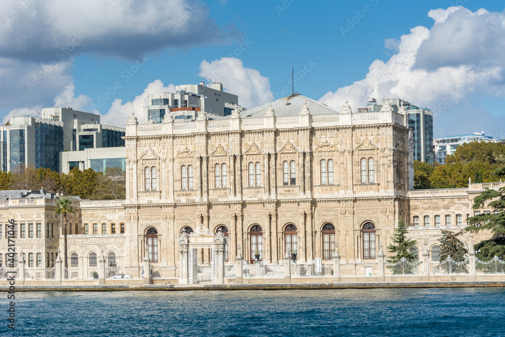 Dolmabahce Palace in the Bosphorus strait in Istanbul Turkey from ferry on a sunny day with background of cloudy sky