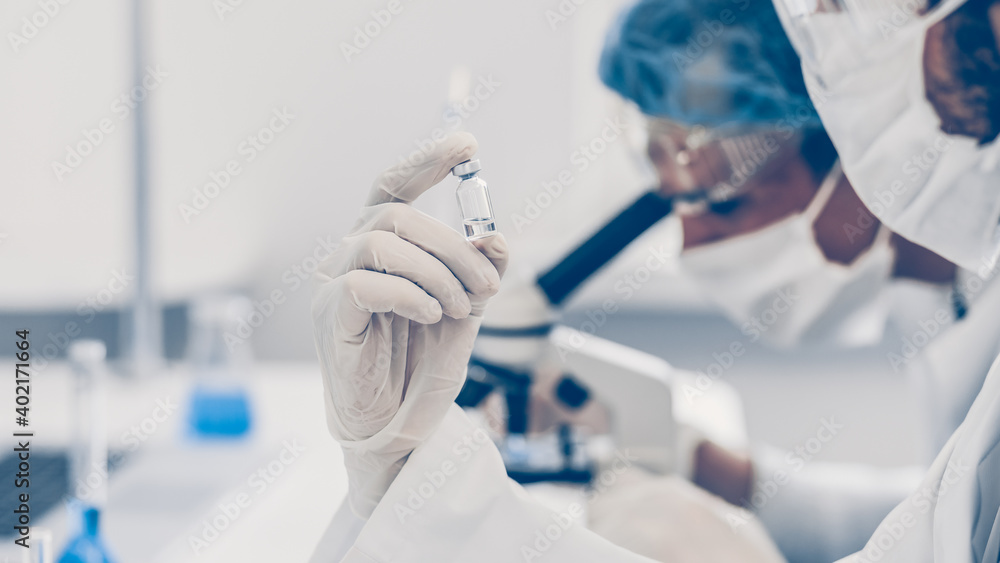 close up. ampoule with a new vaccine in the hands of a scientist. close up. ampoule with a new vaccine in the hands of a scientist.