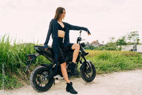 Positive slim woman sitting on bike and looking away
