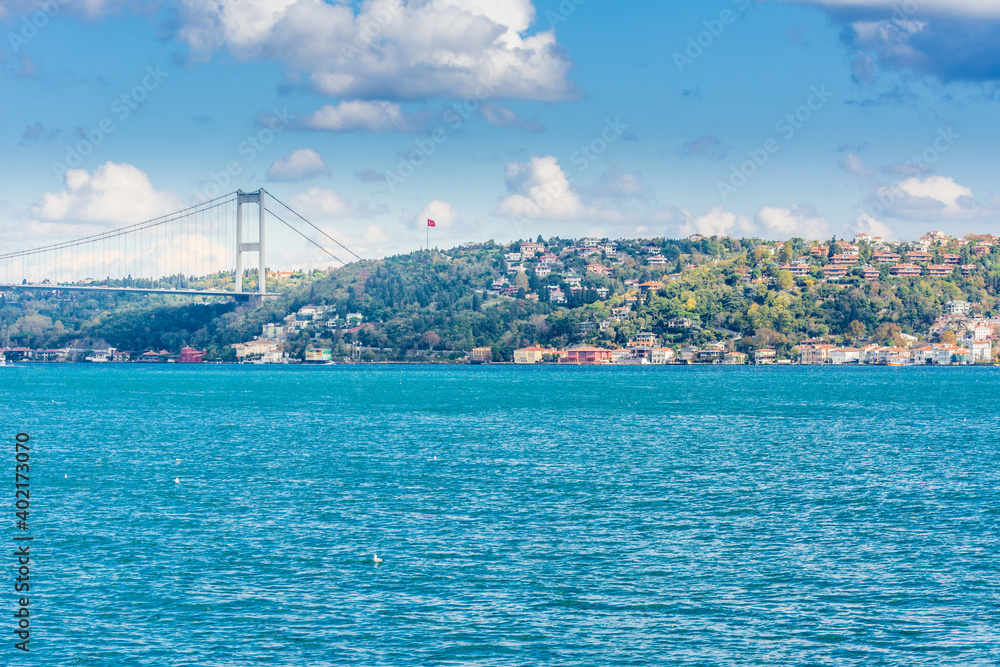 Fatih Sultan Mehmet Bridge with background of Bosphorus strait cityscape on a sunny day with background cloudy blue sky and blue sea in Istanbul, Turkey. Blue Turkey concept.