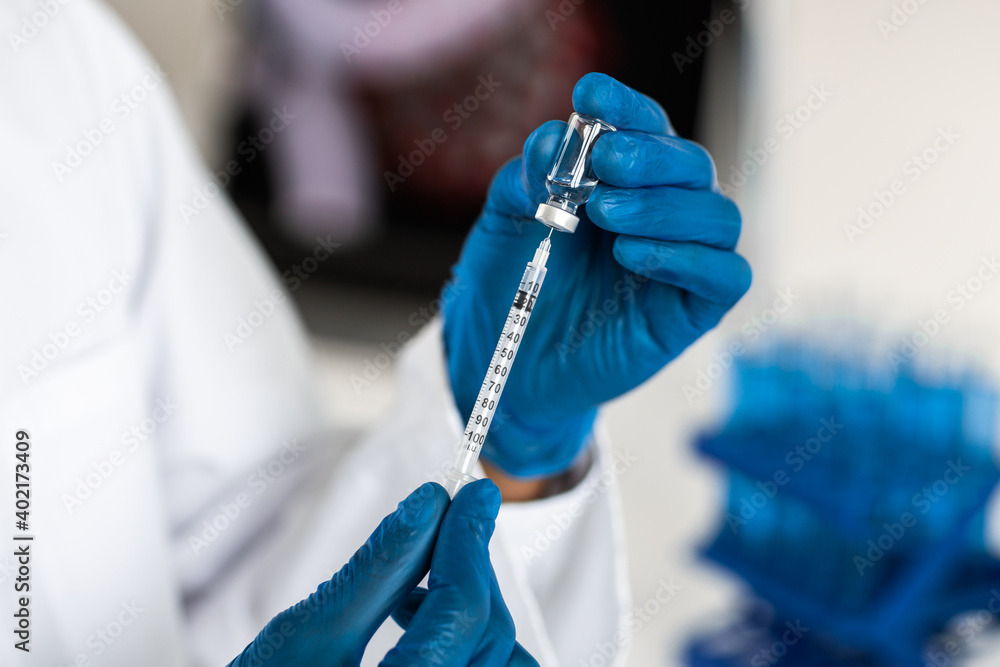 close up. scientist filling a syringe with a new vaccine. close up. scientist filling a syringe with a new vaccine.