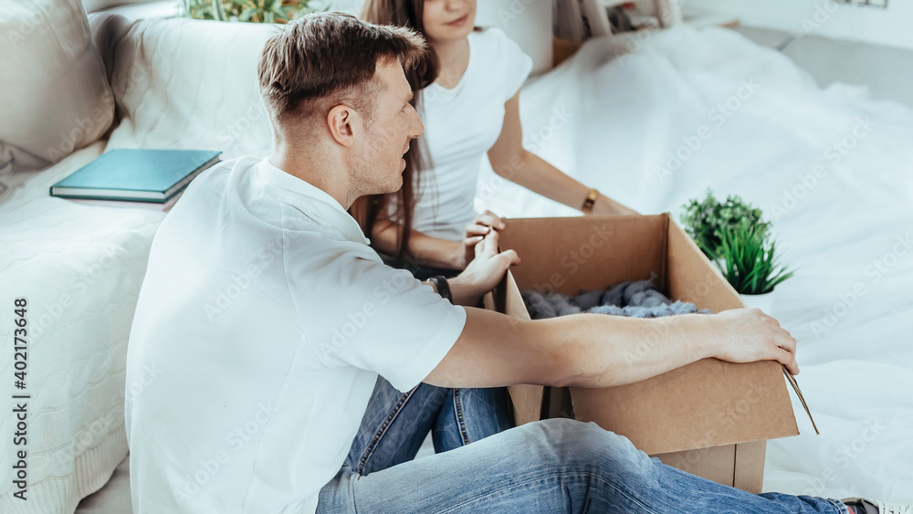 Obraz premium couple opening a cardboard box in a new apartment .