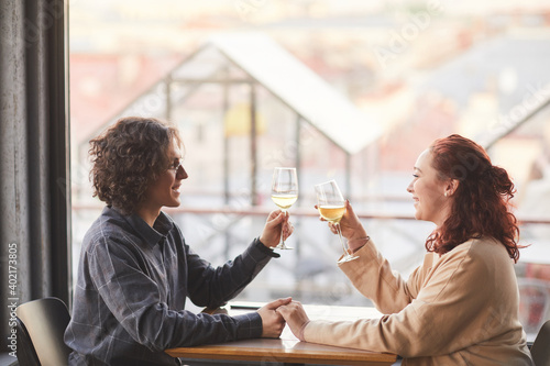 Young couple have romantic date in the restaurant they sitting at the table with glasses of champagne
