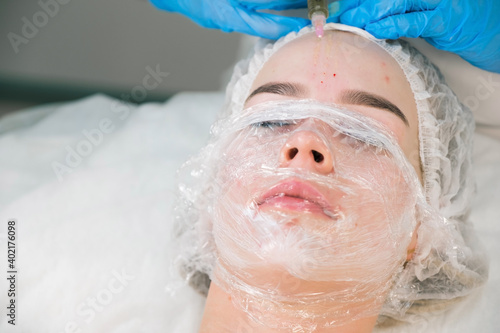 PRP therapy in beauty clinic. Cosmetologist doing injections of blood plasma to womans forehead to cure problem skin, closeup top view. Treatment of skin in cosmetology for young female. photo