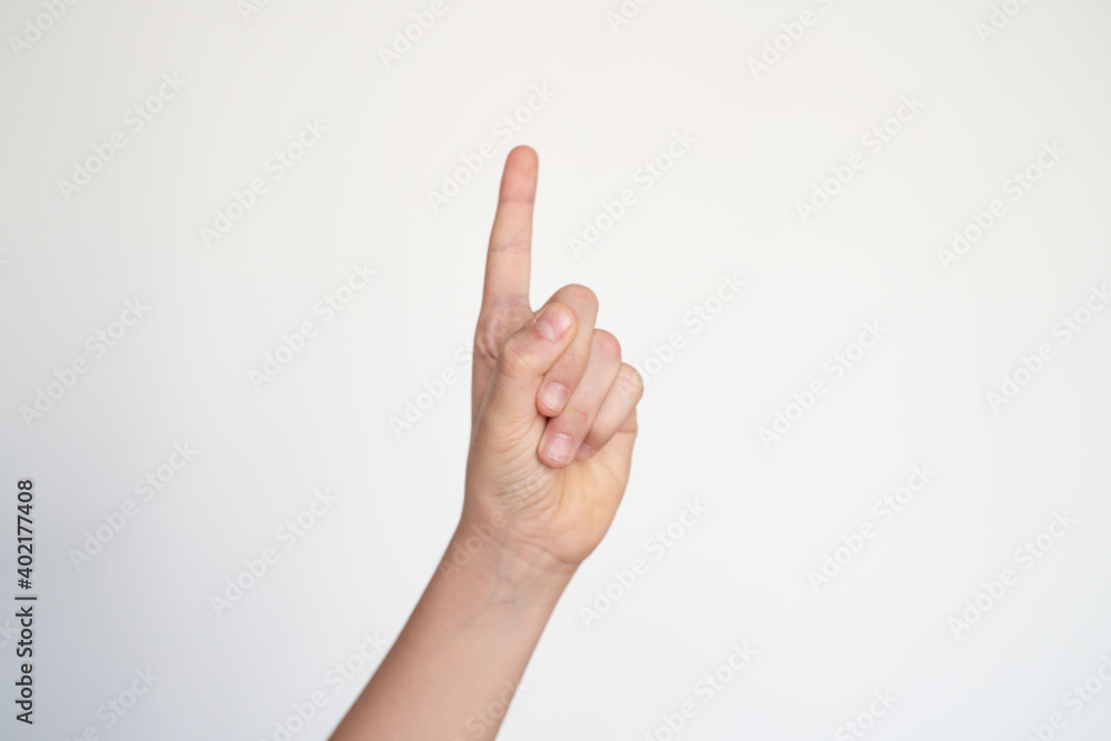 isolated child hand shows the number one. young hand gesture sign. raising hand. ask to speak. pointing finger. isolated child hand shows the number one. young hand gesture sign. raising hand. ask to speak. pointing finger.