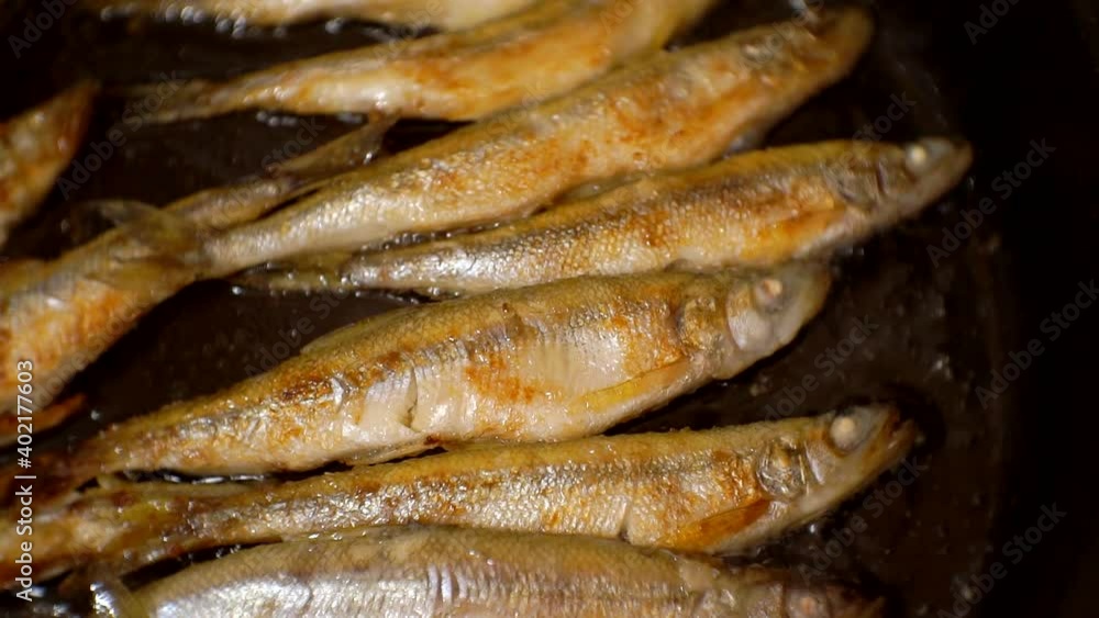 seafood cooking process.fish is fried in oil in a pan.close-up. seafood cooking process.fish is fried in oil in a pan.close-up.