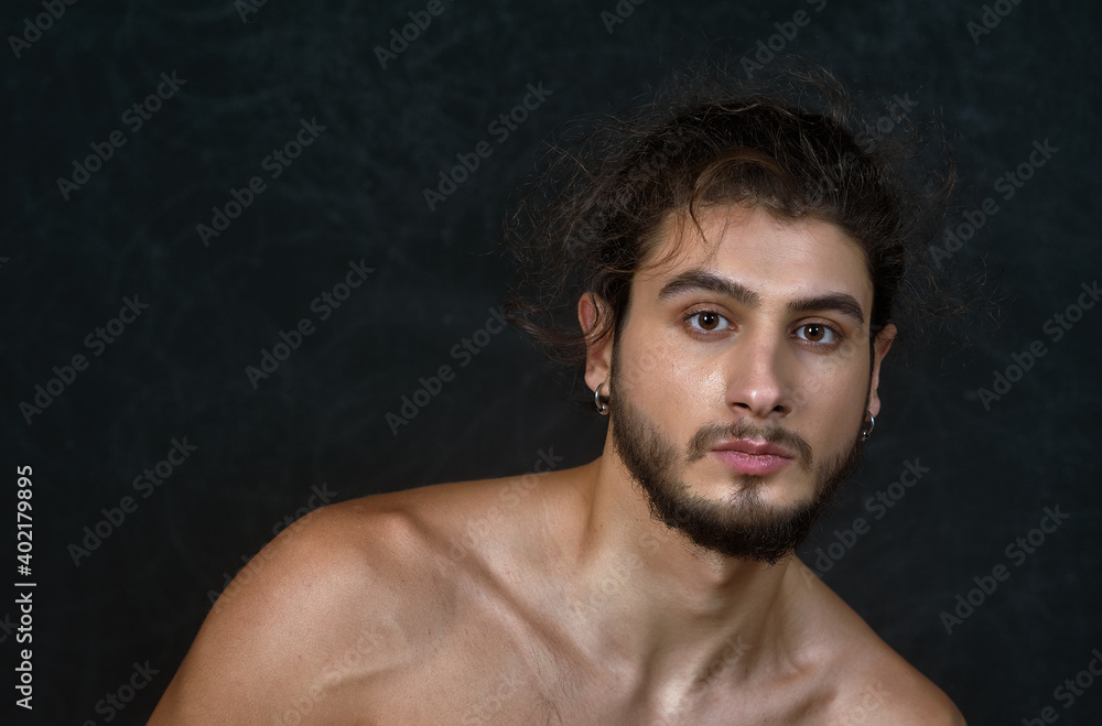 Portrait of a young man in the studio on a dark background