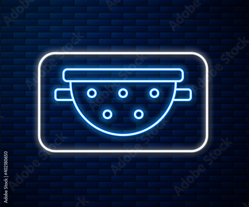 Glowing neon line Kitchen colander icon isolated on brick wall background. Cooking utensil. Cutlery sign. Vector.