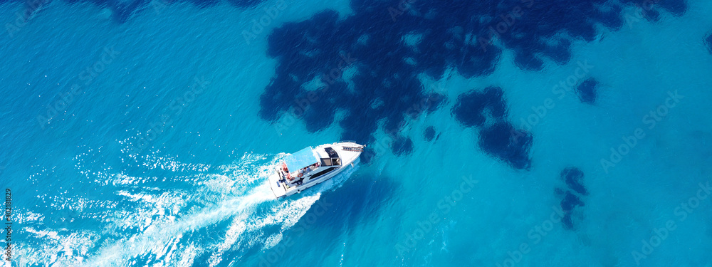 Aerial drone ultra wide photo of tour boat cruising in Caribbean turquoise open ocean sea