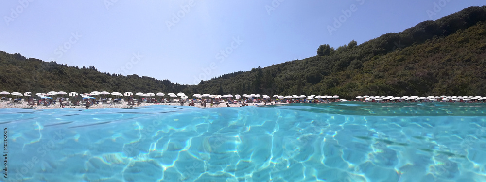 Underwater split ultra wide photo of paradise bay and beach of Voutoumi in island of Antipaxos with crystal clear turquoise sea - popular to sail boats and yachts, Ionian islands, Greece