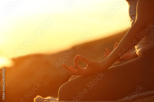 Woman hands at sunset practicing yoga exercises