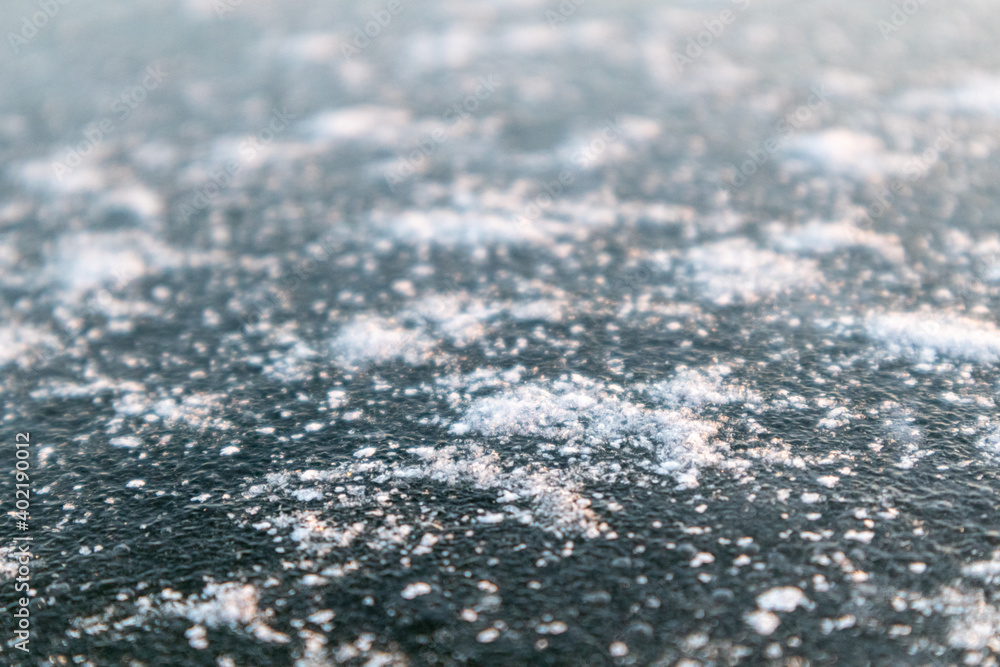 Frozen ice cold deep lake surface covered with snow close-up sparkling in orange sunset light. Blurred background Frozen ice cold deep lake surface covered with snow close-up sparkling in orange sunset light. Blurred background