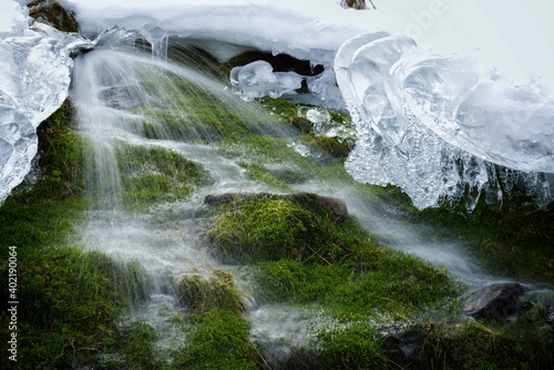a water source with ice crystals in snow on the mountains in winter
