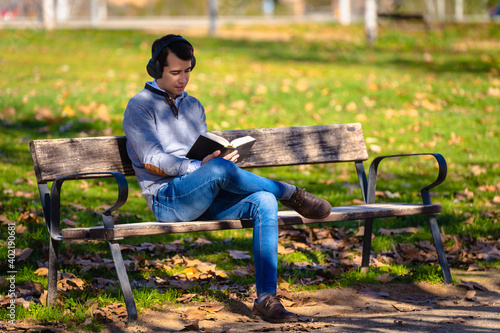 Man sitting in a park reading a book