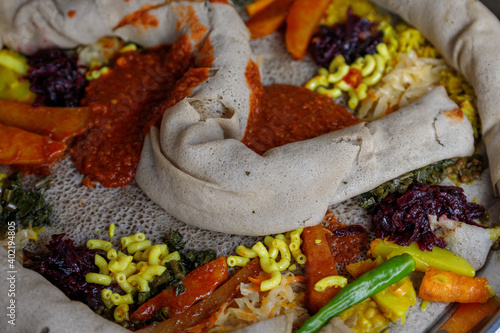 Ethiopian traditional dish, sour pancake with hot pepper sauce and other vegetables