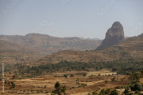 Ethiopia mountain valley landscape with some trees and all yellow-dried grass in dry weather